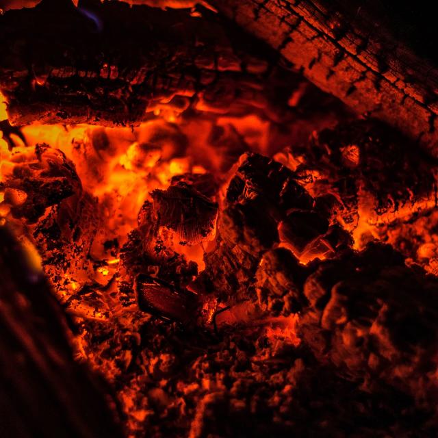 Glowing orange embers around a charred log