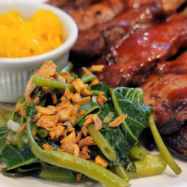 Grilled pork with sautéed water spinach, fried garlic and a small dish of atchara
