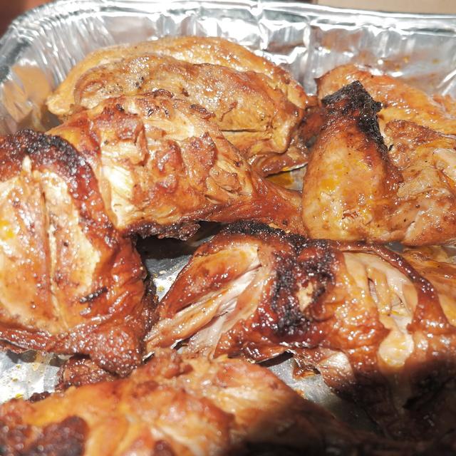 Pieces of grilled chicken inasal in a foil tray